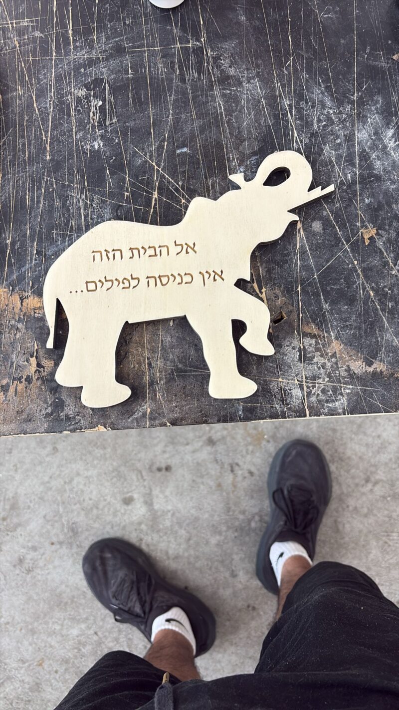שלט עץ בצורת פיל אל הבית הזה אין כניסה לפילים